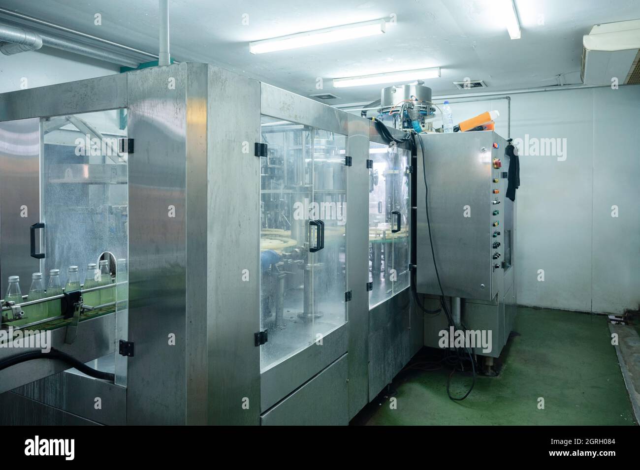 Getränkeabfüllraum mit automatischer Maschine und Bedienfeld in der Produktionslinie der Getränkeverarbeitungsfabrik Stockfoto