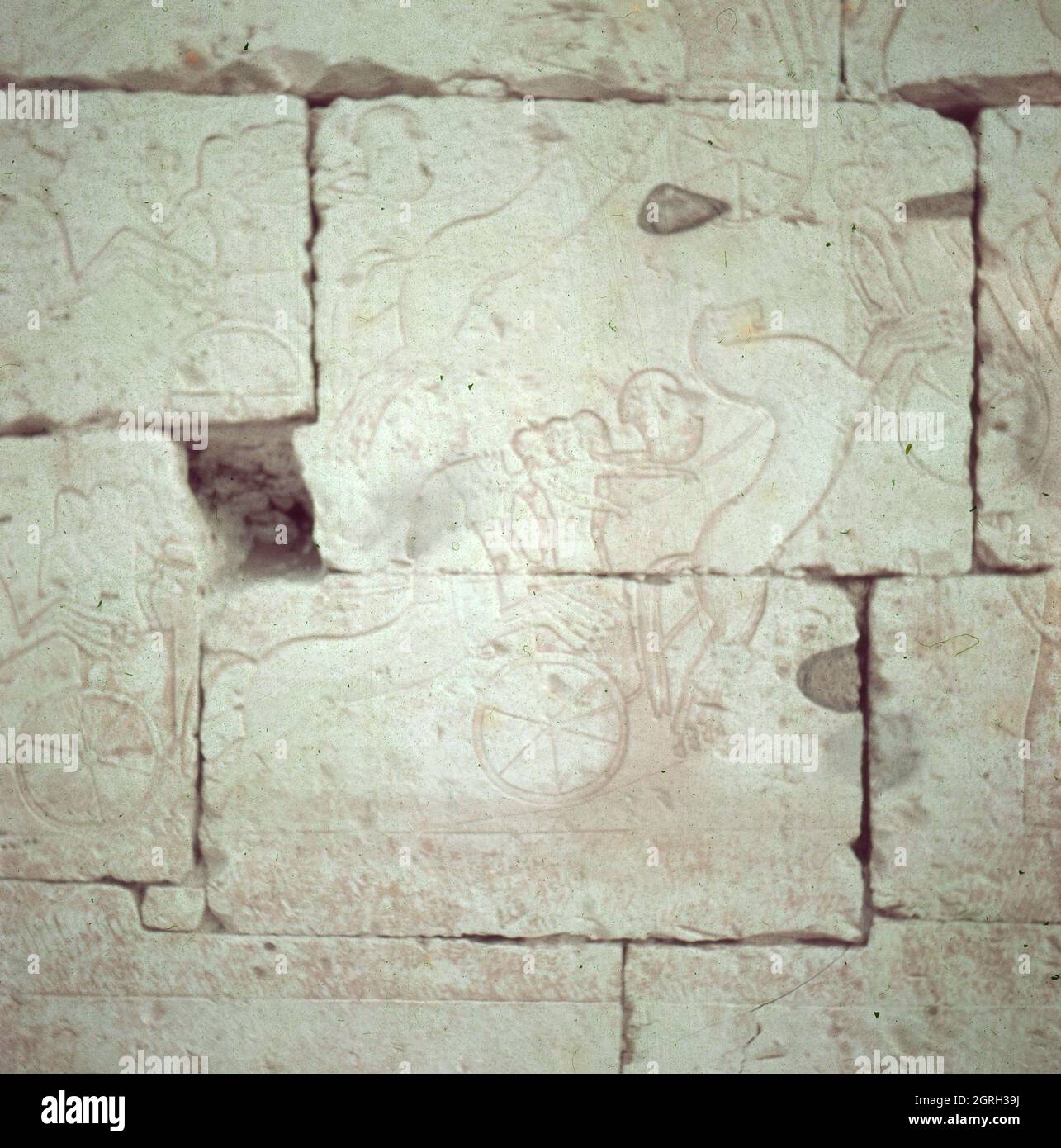 Streitwagen fahren gegen eine Stadt auf einem Wandrelief in einem Tempel, Ägypten 1955. Wagen wüten gegen Stadtmauern auf Amuralrelief an einer Tempelmauer, Ägypten 1955. Stockfoto