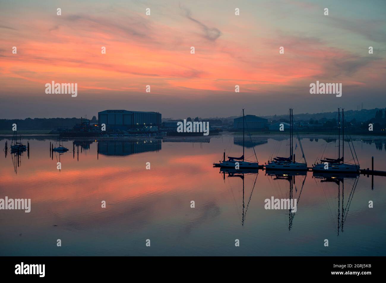 Segelyachten, die bei Sonnenuntergang in einem ruhigen Hafen auf einem Ponton festgemacht haben. Stockfoto