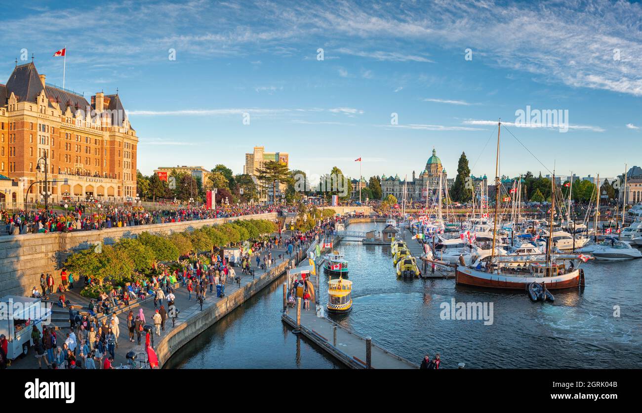 Canada Day in Victoria, Vancouver Island, Kanada. Massen von Menschen besuchen die Feierlichkeiten am Binnenhafen mit dem parlamentsgebäude während Sonnen Stockfoto