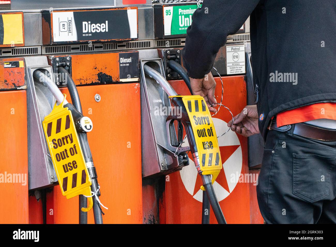 Ein Mitarbeiter bindet an einer Tankstelle im Zentrum von London ein Schild „orry out of use“ an die Zapfsäulen. Bilddatum: Freitag, 1. Oktober 2021. Stockfoto