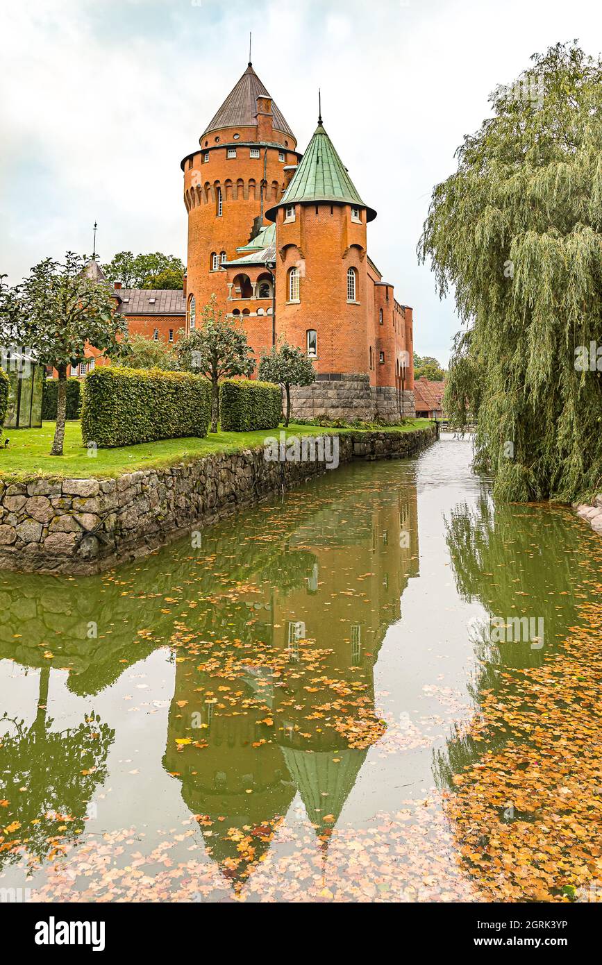Hjularod ist eine romantische rote Burg mit hohen Türmen, die sich im Graben spiegeln, Eslov, Schweden, 16. September 2021 Stockfoto