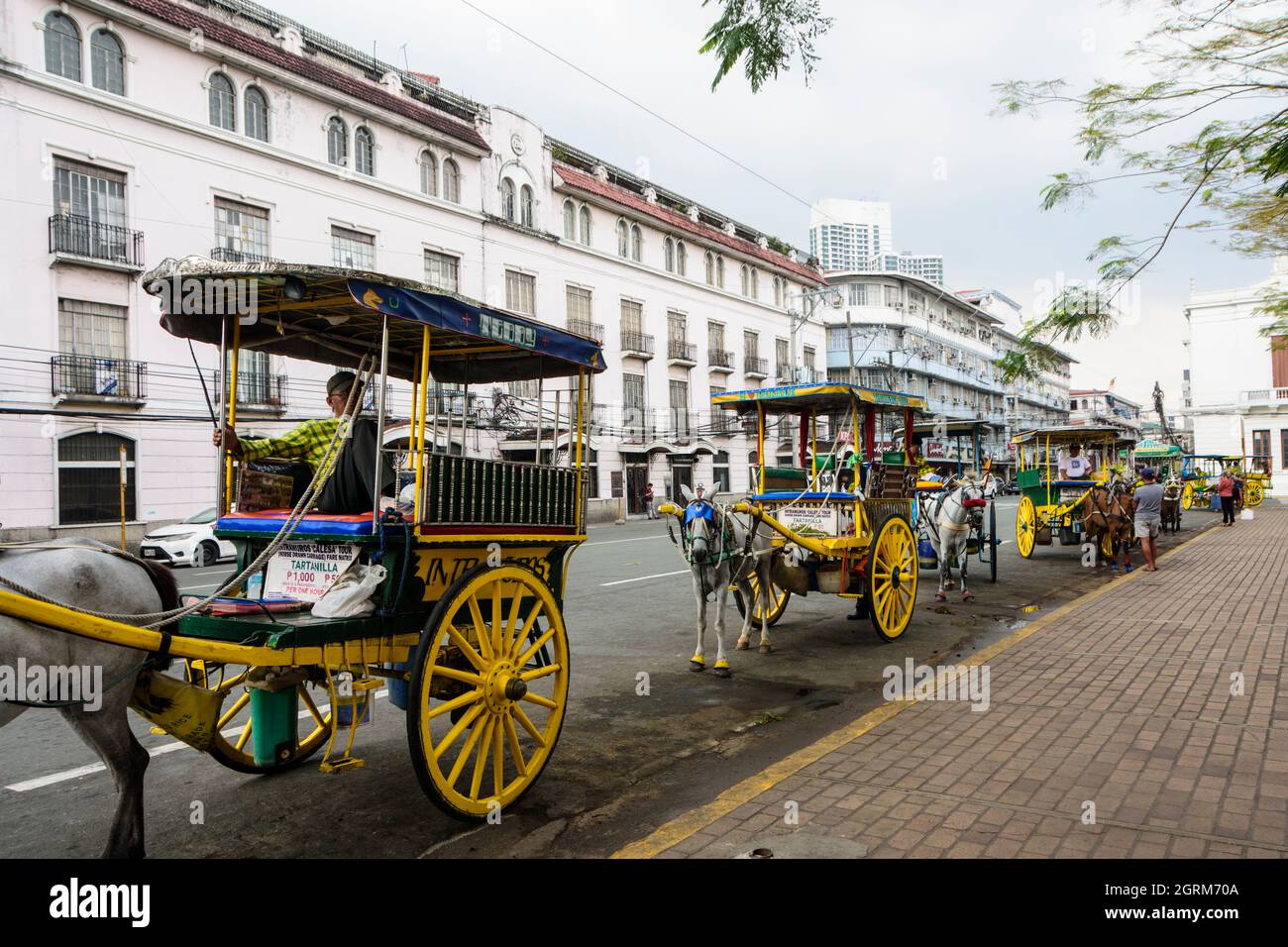Geparkte Tartanillas (Pferdekutschen mit zwei seitlichen Bänken) in Manila, Philippinen Stockfoto