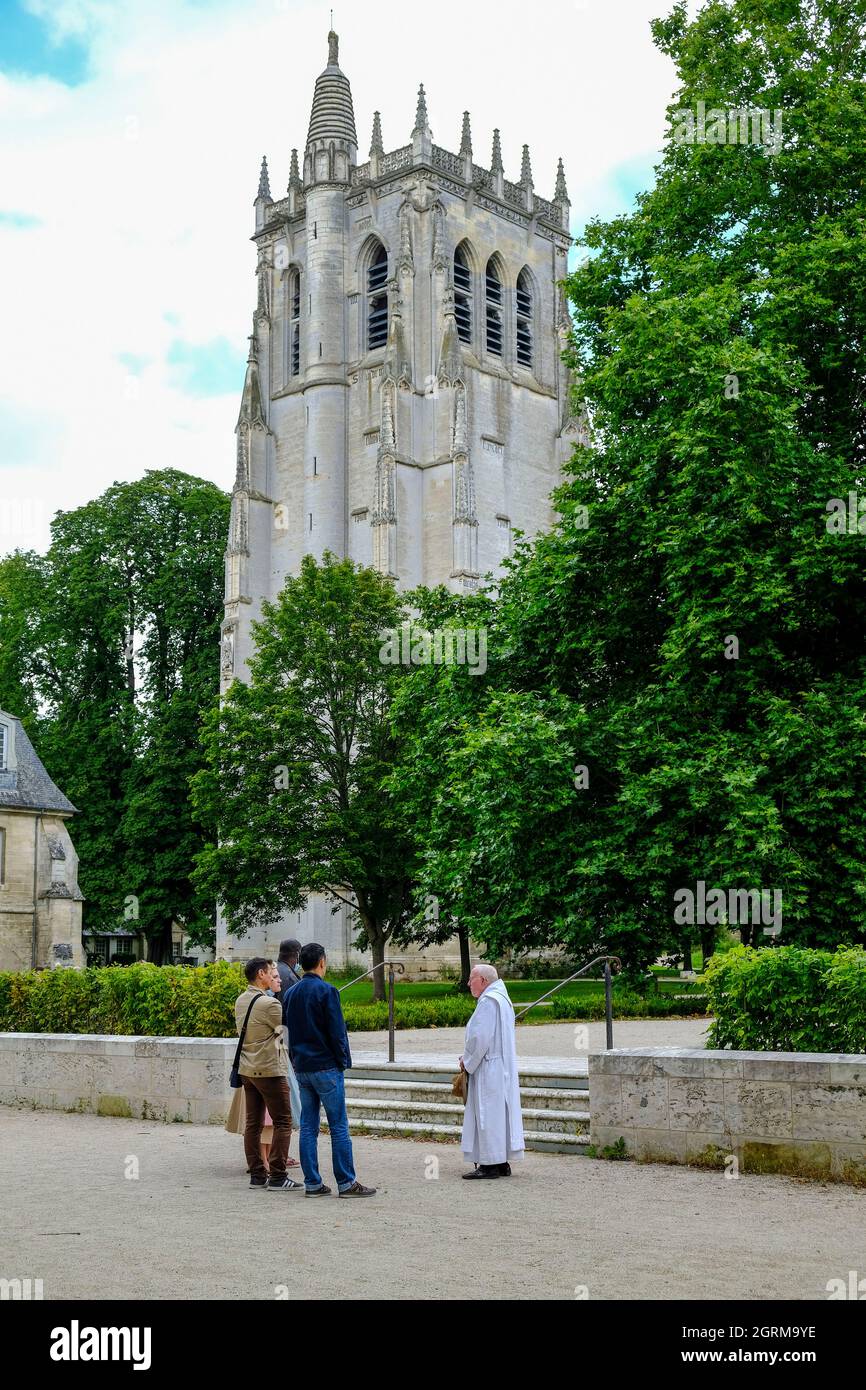 Frankreich, Le Bec-Hellouin, 28.08.2021: Besucher auf dem Gelände der Abtei Le Bec mit dem Turm Saint-Nicolas im Hintergrund im Gespräch mit einem P Stockfoto