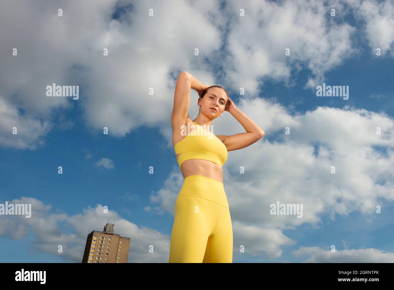 Sportliche und fit junge Sportlerin mit blauem Himmel Hintergrund. Das Konzept eines gesunden Lebensstils und Sports. Stockfoto