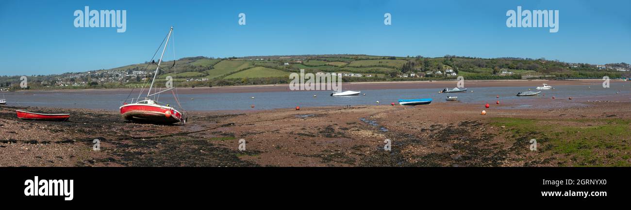 Panoramablick mit einer kleinen roten Yacht und anderen Booten, die auf niedrigem Wasser in der Flussmündung Teign in der Nähe von Teignmouth South Devon England auf Grund gehen Stockfoto