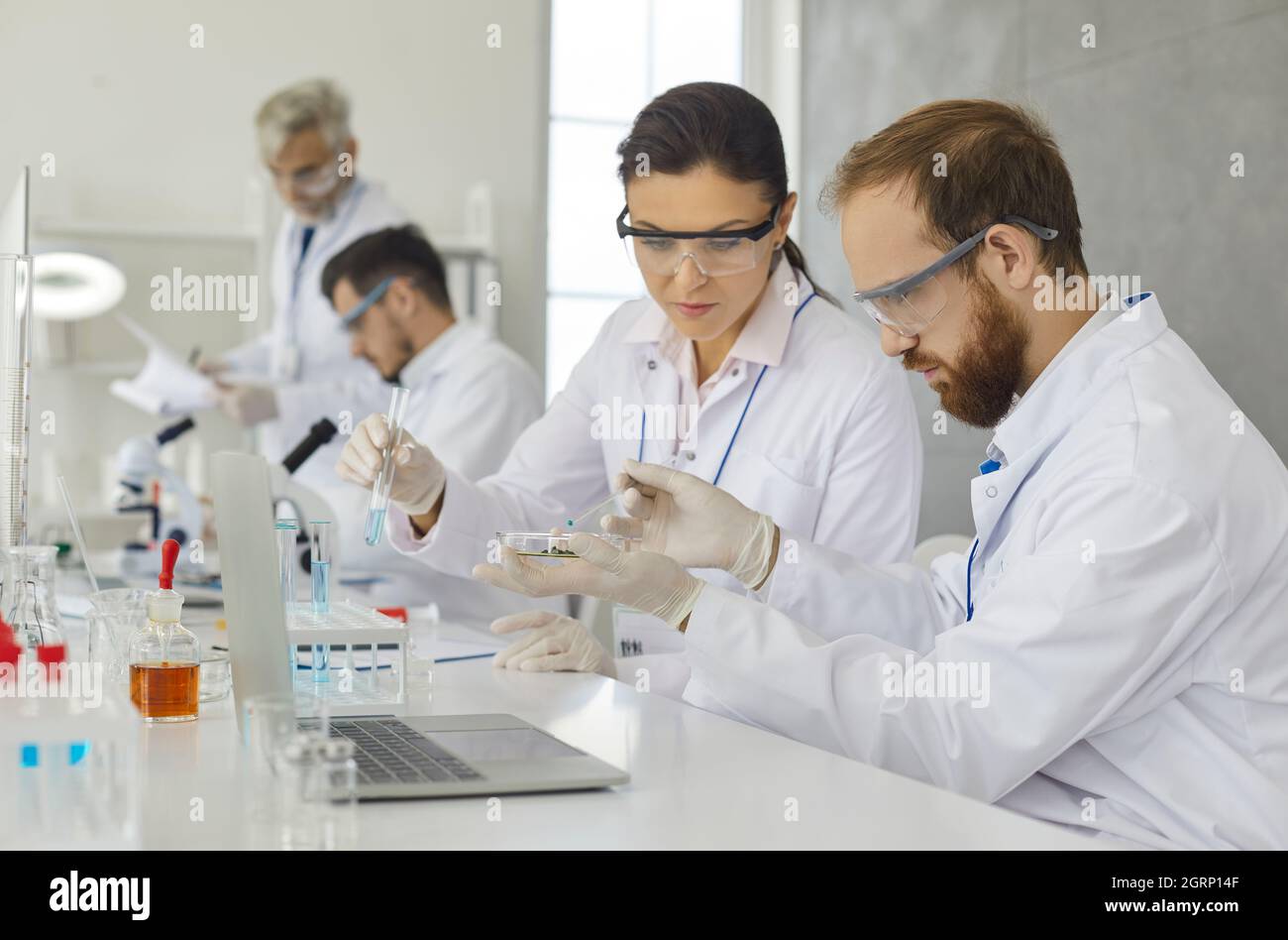 Team von Wissenschaftlern, die Proben analysieren, während sie in einem modernen Forschungslabor arbeiten. Stockfoto