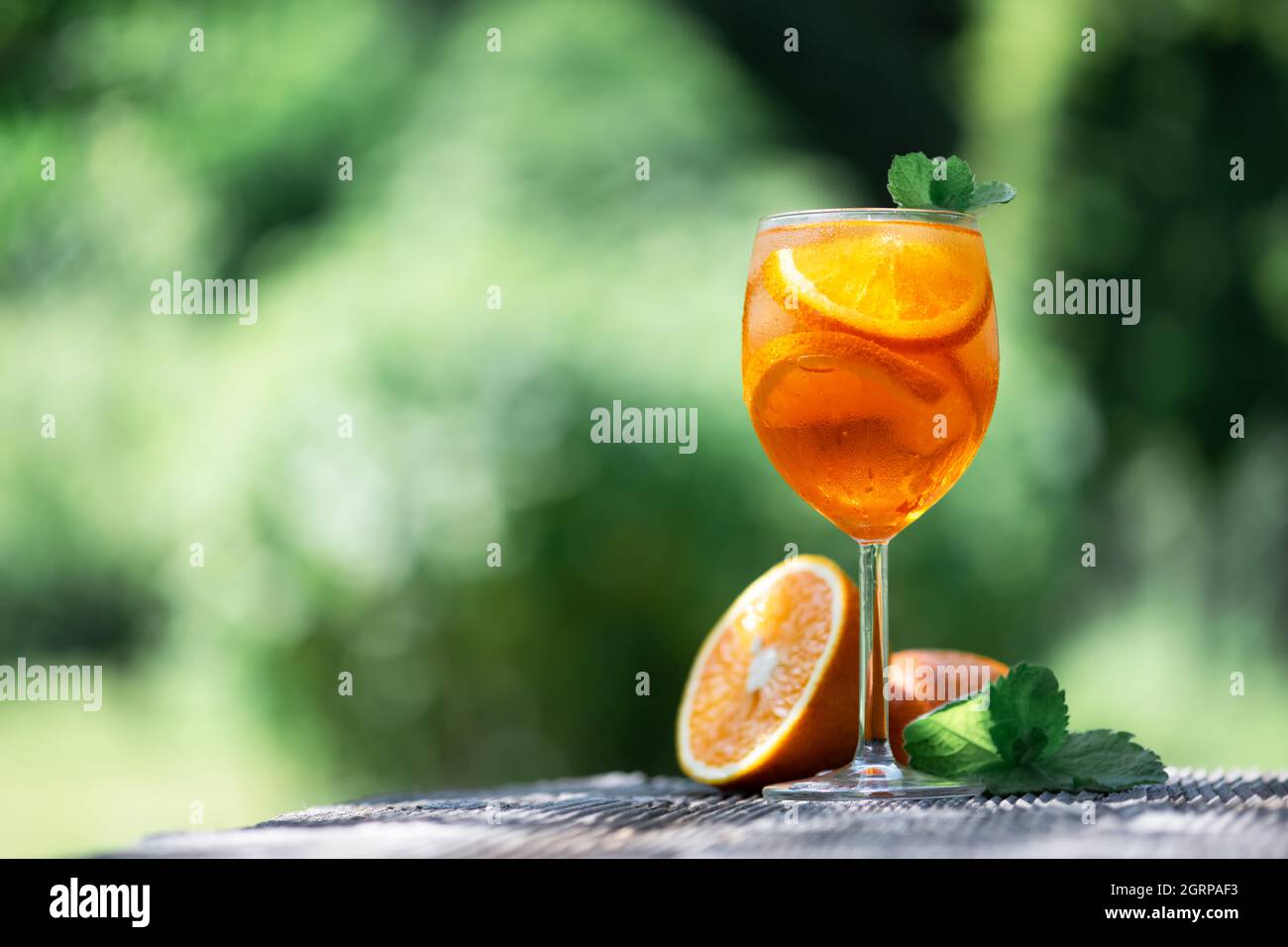 Aperol Spritz Aperitivo Sommercocktail in Originalglas mit Orangen und Minzzweig auf Holztischhintergrund. Fotos von Speisen und Getränken Stockfoto