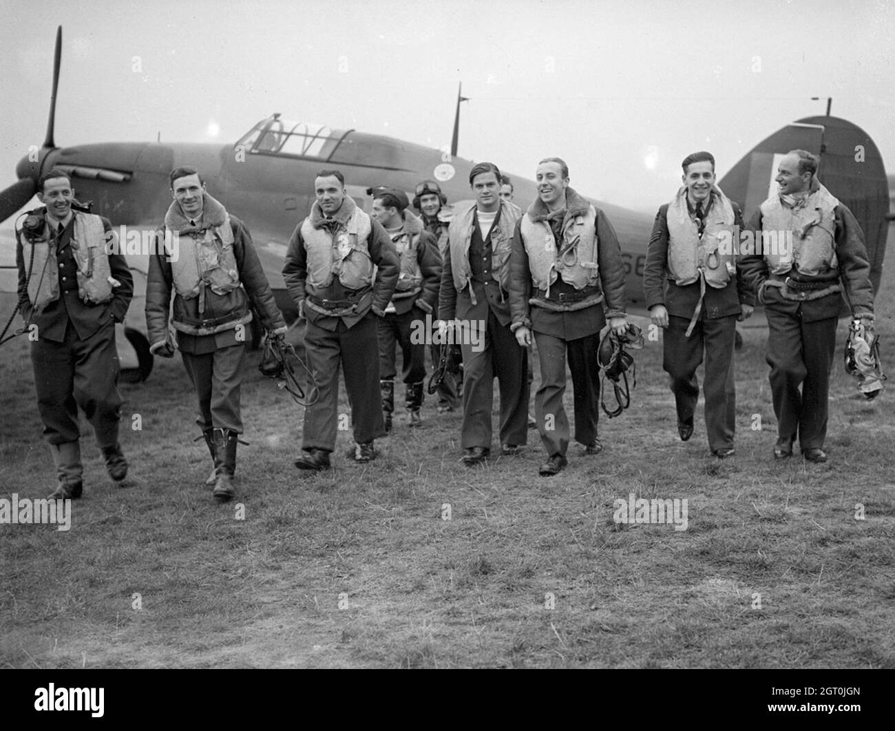 Piloten der RAF-Staffel Nr. 303 (Polen) mit einem ihrer Hawker Hurricanes, Oktober 1940. Von links nach rechts, in der ersten Reihe sind; Pilot Officer Mirosław Ferić, Flugleutnant John A Kent (Kommandant des Fluges A), Flugoffizier Bogdan Grzeszczak, Flugoffizier Jerzy Radomski, Flugoffizier Witold Łokuciewski, Flugoffizier Bogusław Mierzwa (verdeckt von Łokuciewski), Flugoffizier Zdzisław Henneberg, Sergeant Jan Rogowski und Sergeant Eugeniusz Szaposznikow. In der Mitte, hinten in dieser Gruppe, trägt der Flying Officer Jan Zumbach Helm und Brille. Stockfoto