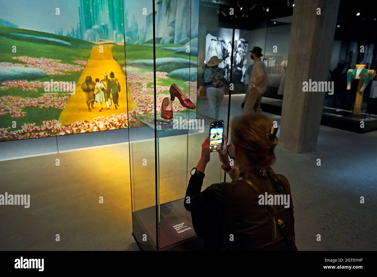 Besucher, der in einer Ausstellung „Wizard of Oz“ im Academy Museum of Motion Picters, Los Angeles, Kalifornien, ein iPhone-Foto von Dorothys Rubschuhen macht Stockfoto