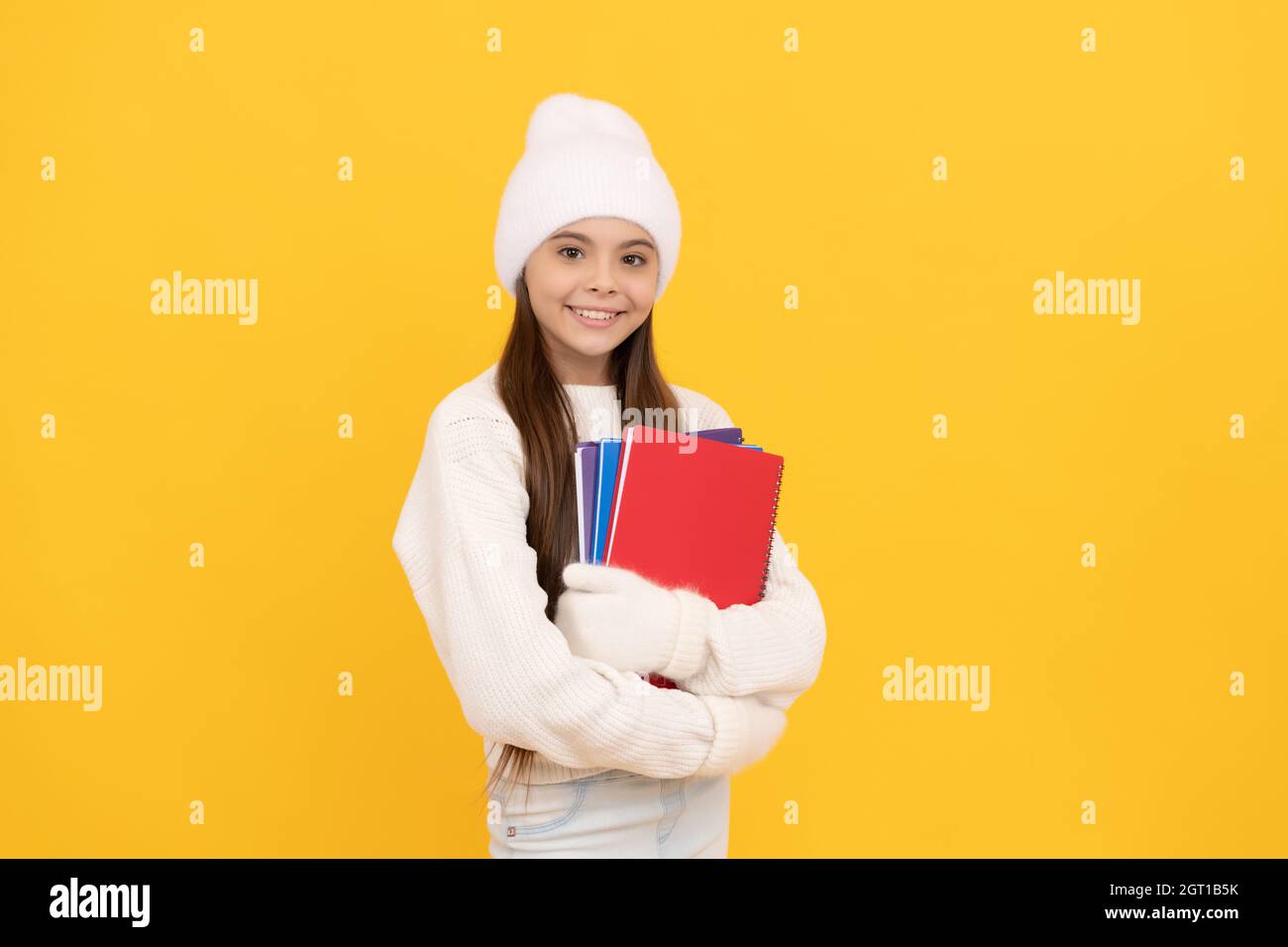 Glückliche Kindheit. Jugendliches Mädchen im Urlaub. Wintermode. Glückliches Kind im Winterhut und Handschuhe. Stockfoto