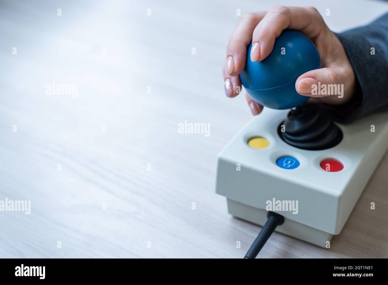 Frau mit zerebraler Lähmung arbeitet an einer spezialisierten Computermaus. Stockfoto