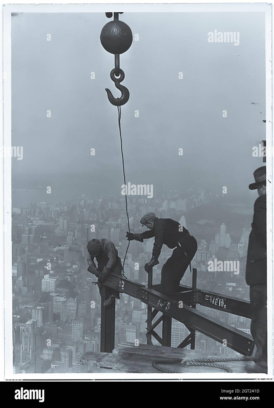 EMPIRE STATE BUILDING NY, NY 1930 - 1931. Allgemeine und detaillierte Ansichten des im Bau befindlichen Empire State Building, in denen Arbeiter verschiedene Aufgaben wie das Positionieren, Schweißen und Nieten von Stahl, das Heben von Materialien und Hilfsgütern sowie das Betreiben und Reparieren von Maschinen zeigen. Es gibt auch eine Vogelperspektive auf Midtown Manhattan, die andere Gebäude zeigt, die im Bau sind. Fotografien von: Hine, Lewis Wickes, 1874-1940 . Stockfoto