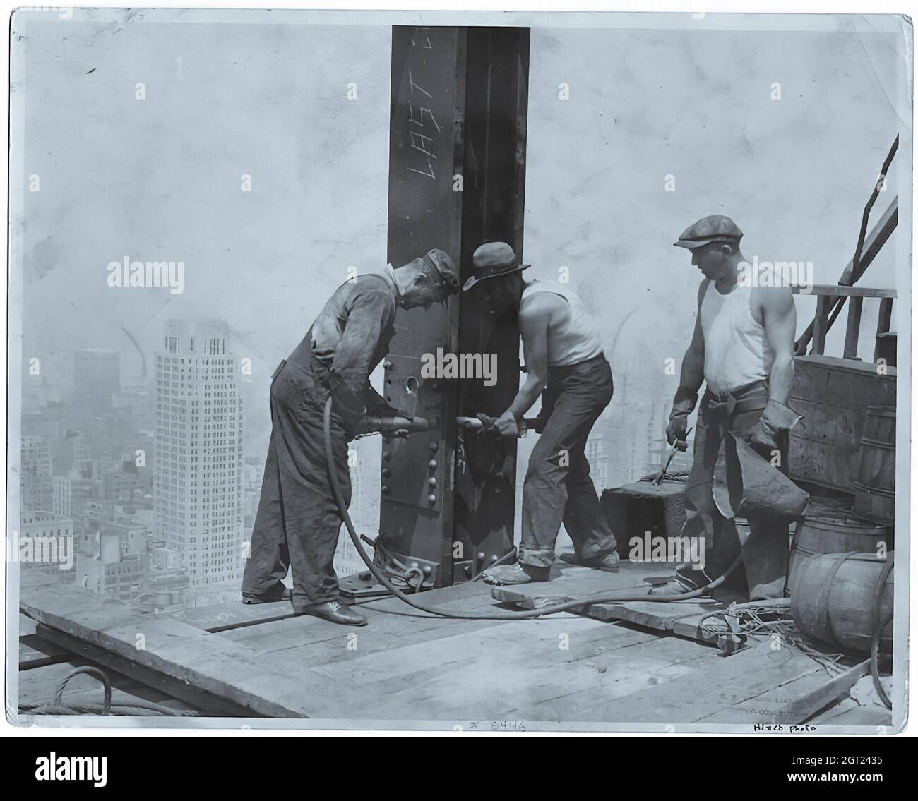 EMPIRE STATE BUILDING NY, NY 1930 - 1931. Allgemeine und detaillierte Ansichten des im Bau befindlichen Empire State Building, in denen Arbeiter verschiedene Aufgaben wie das Positionieren, Schweißen und Nieten von Stahl, das Heben von Materialien und Hilfsgütern sowie das Betreiben und Reparieren von Maschinen zeigen. Es gibt auch eine Vogelperspektive auf Midtown Manhattan, die andere Gebäude zeigt, die im Bau sind. Fotografien von: Hine, Lewis Wickes, 1874-1940 . Stockfoto