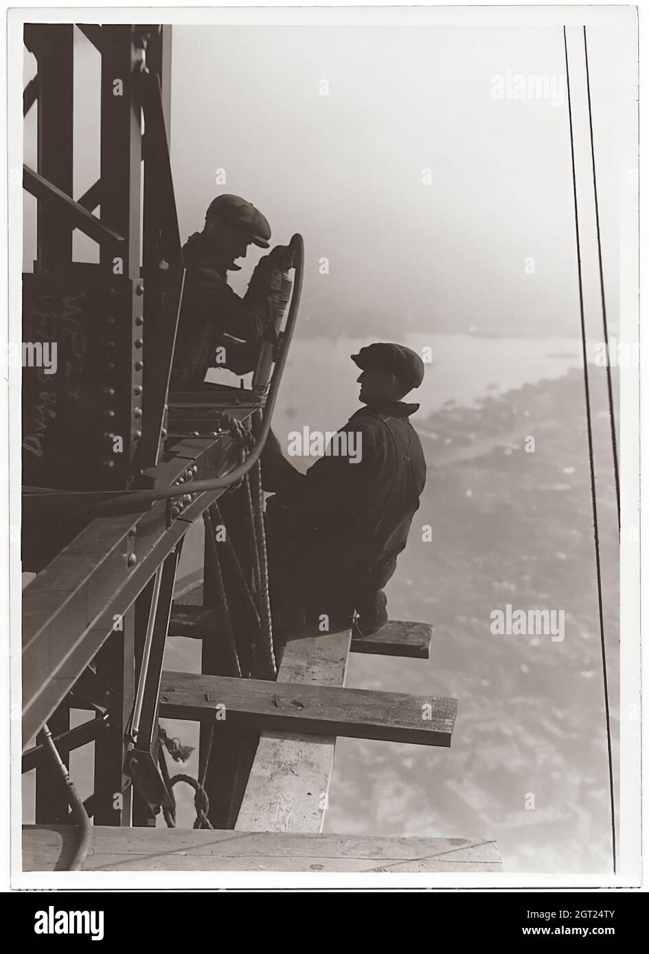 EMPIRE STATE BUILDING NY, NY 1930 - 1931. Allgemeine und detaillierte Ansichten des im Bau befindlichen Empire State Building, in denen Arbeiter verschiedene Aufgaben wie das Positionieren, Schweißen und Nieten von Stahl, das Heben von Materialien und Hilfsgütern sowie das Betreiben und Reparieren von Maschinen zeigen. Es gibt auch eine Vogelperspektive auf Midtown Manhattan, die andere Gebäude zeigt, die im Bau sind. Fotografien von: Hine, Lewis Wickes, 1874-1940 . Stockfoto