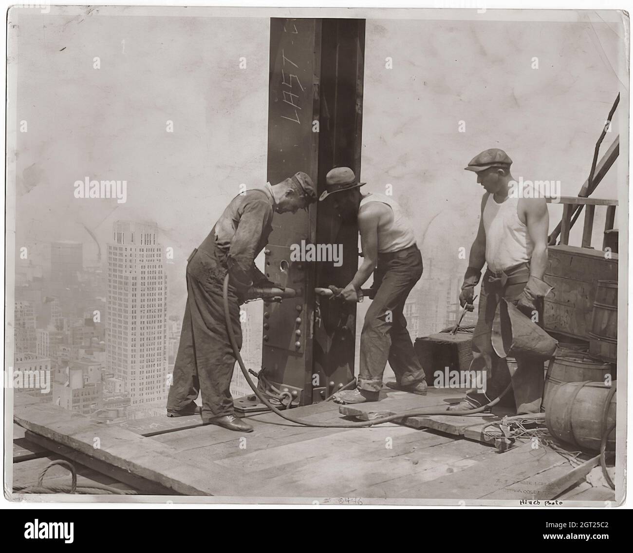 EMPIRE STATE BUILDING NY, NY 1930 - 1931. Allgemeine und detaillierte Ansichten des im Bau befindlichen Empire State Building, in denen Arbeiter verschiedene Aufgaben wie das Positionieren, Schweißen und Nieten von Stahl, das Heben von Materialien und Hilfsgütern sowie das Betreiben und Reparieren von Maschinen zeigen. Es gibt auch eine Vogelperspektive auf Midtown Manhattan, die andere Gebäude zeigt, die im Bau sind. Fotografien von: Hine, Lewis Wickes, 1874-1940 . Stockfoto