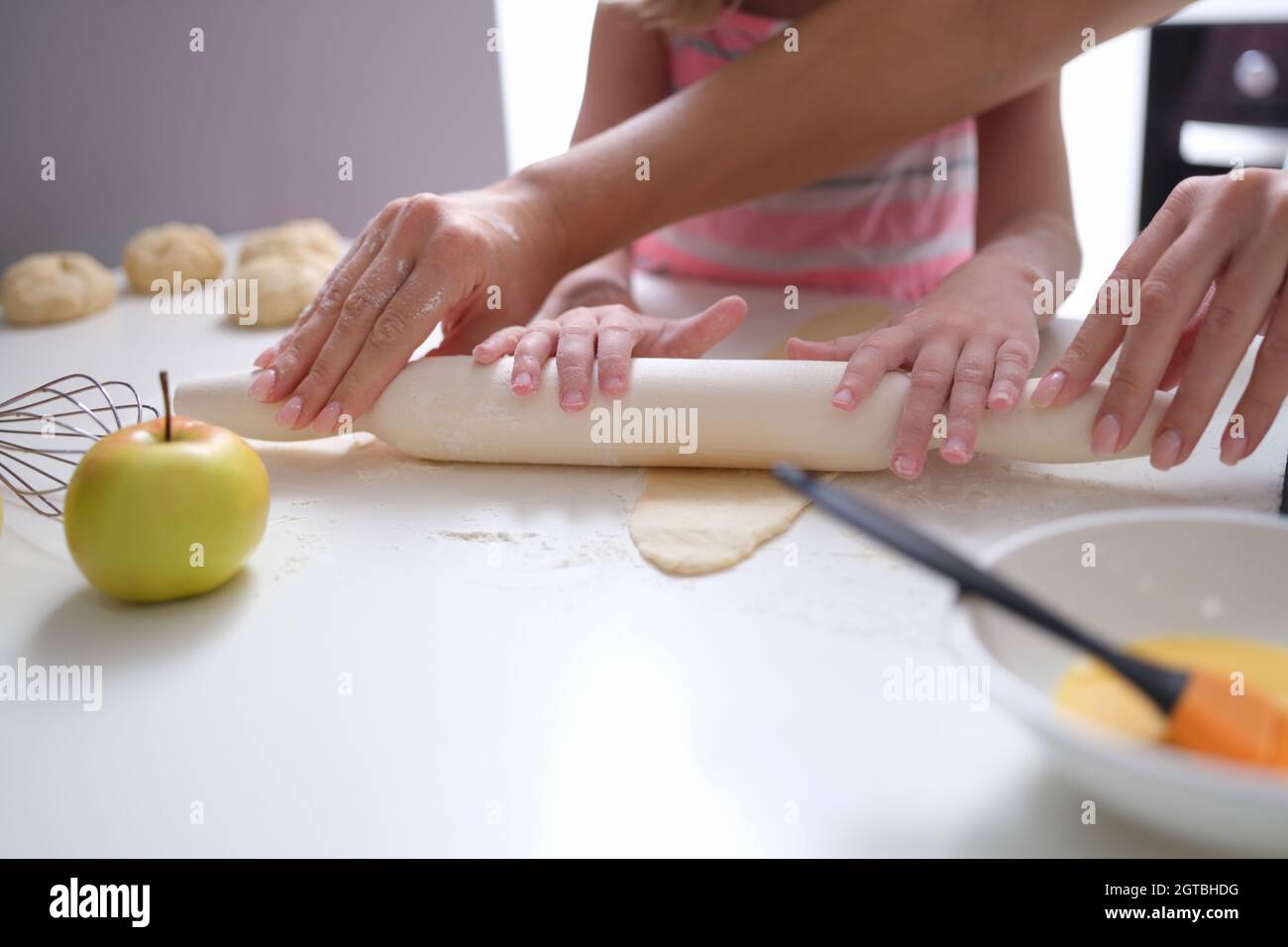 Mama und Tochter Rollen in der Küche Teig mit Nudelholz aus Stockfoto