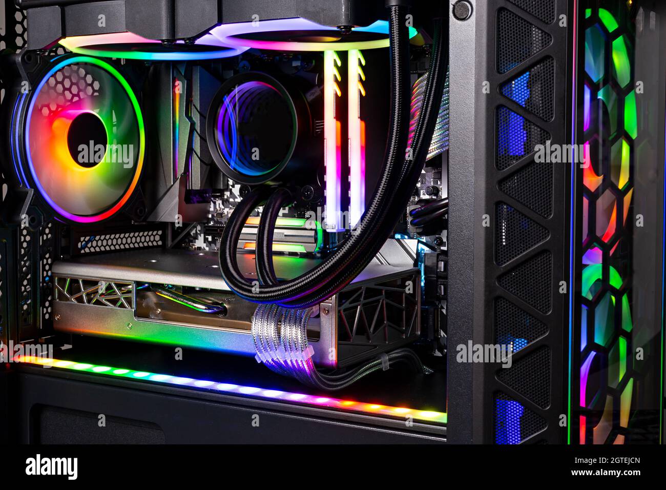 Innenansicht des schwarzen High-End-Gaming-pcs mit farbenfroh beleuchtetem, strahlendem Regenbogen-RGB-LED. Hintergrund des Computer-Power-Hardware- und Technologiekonzepts Stockfoto