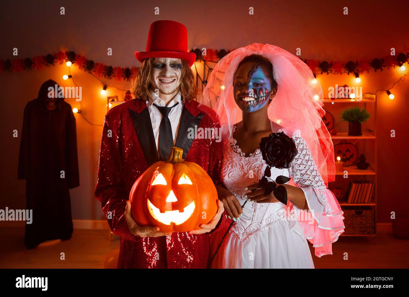 Fröhlicher junger Mann und Frau, die als tote Hochzeitsgesellschaft für eine Halloween-Party gekleidet sind Stockfoto