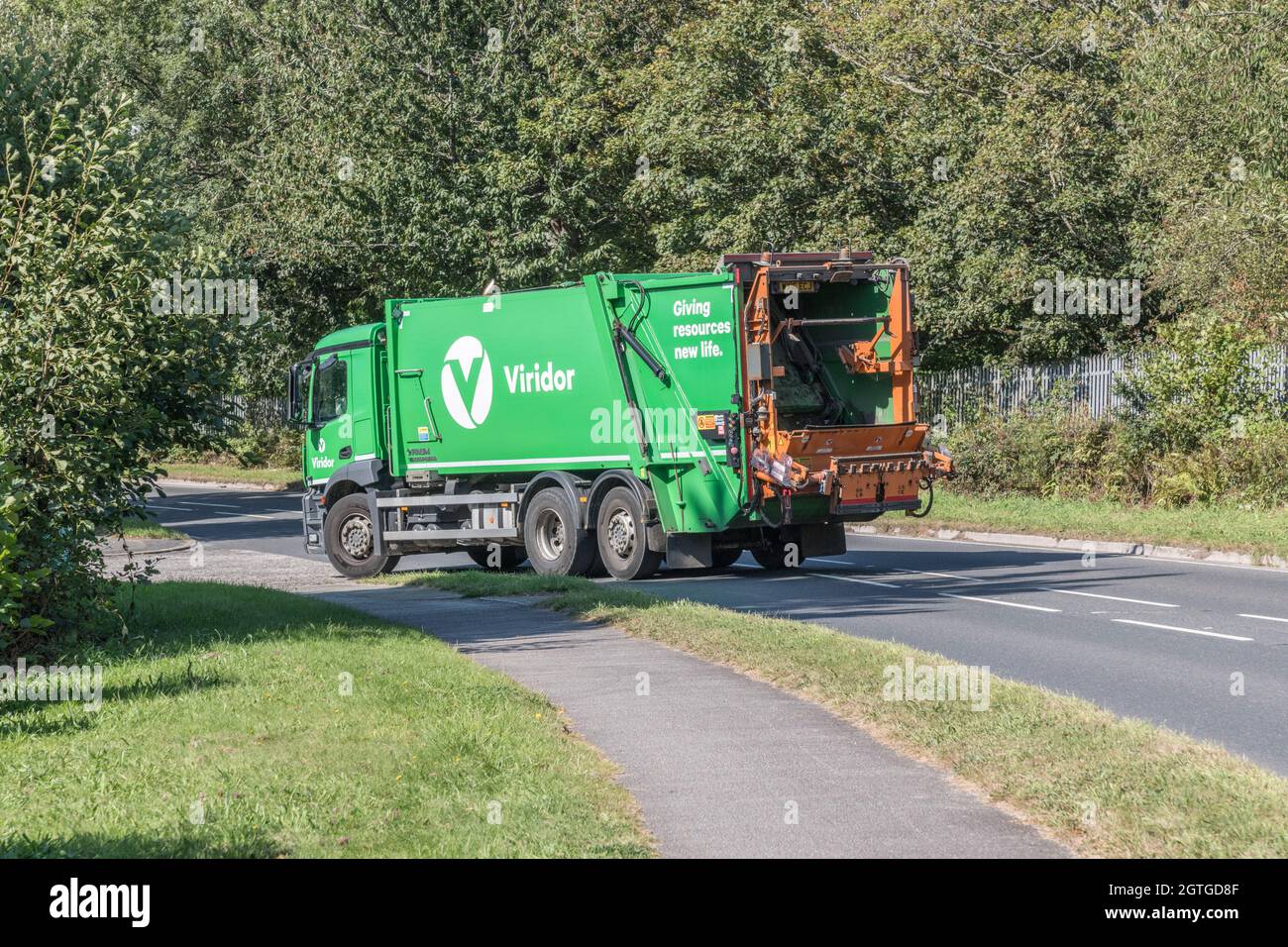 Green Viridor Faun Variopress Waste Truck fährt bergab auf der Landstraße. Für den Mangel an britischen Fahrern, Müllabfuhr während des Transports in Covid, Großbritannien Stockfoto