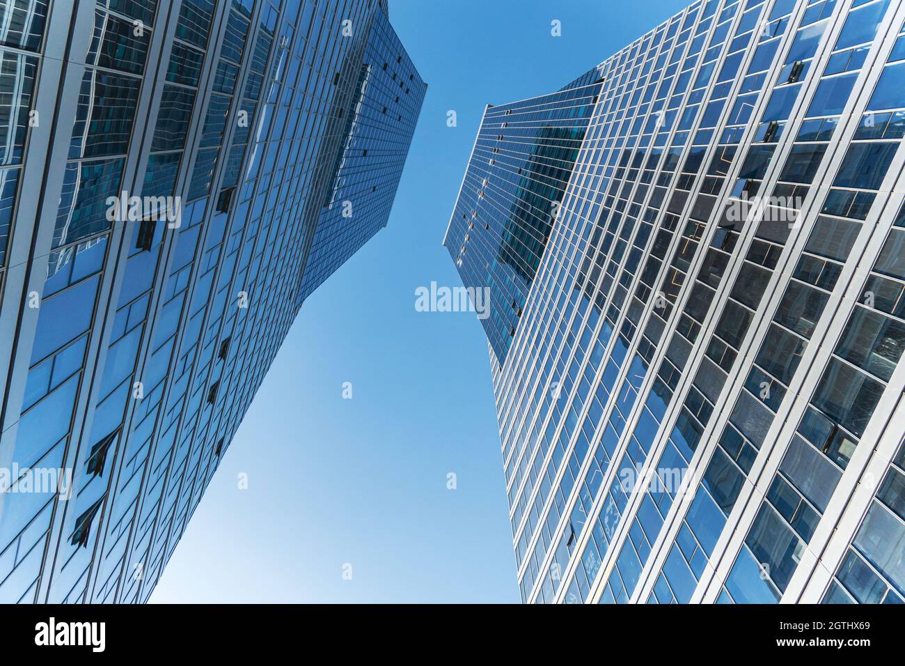 Futuristische Fassade eines modernen, mit Glas verkleideten Bürogebäudes. Glasverkleidungen und Fenster eines modernen Gebäudes. Ein Bürogebäude mit Geometrie und Stockfoto