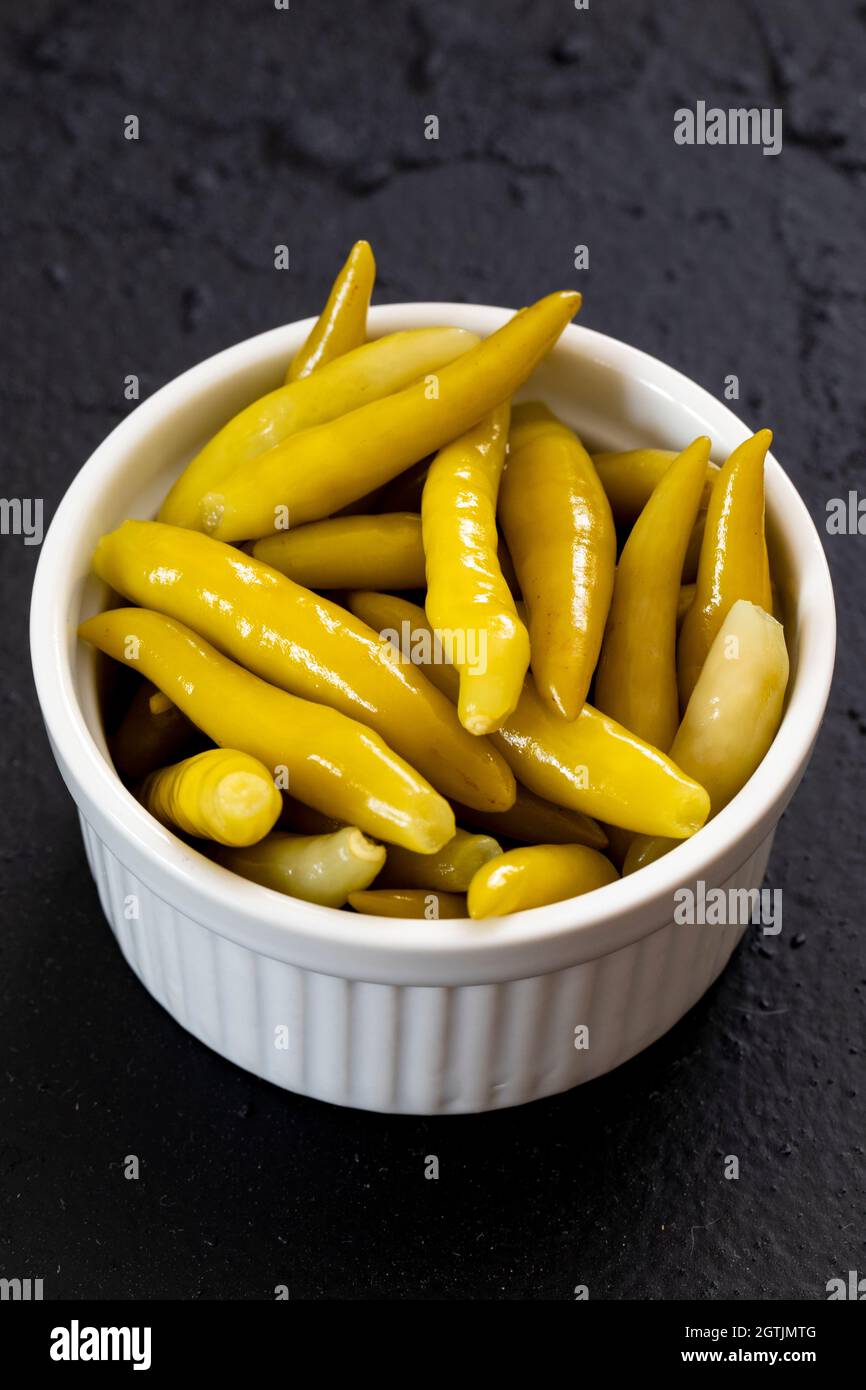 Grüner Chilischote auf dunklem Grund eingelegt Stockfoto