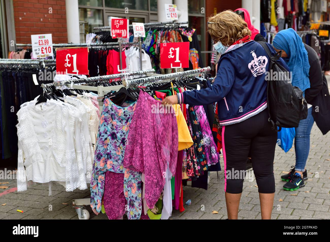 Einkäufer, die auf der Suche nach Kleidung im Birmingham Bullring Rag Market, Großbritannien, sind Stockfoto