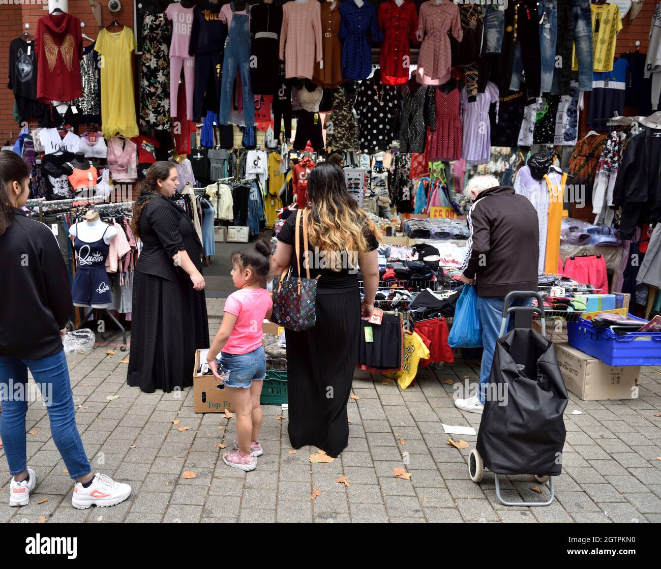 Einkäufer, die auf der Suche nach Kleidung im Birmingham Bullring Rag Market, Großbritannien, sind Stockfoto