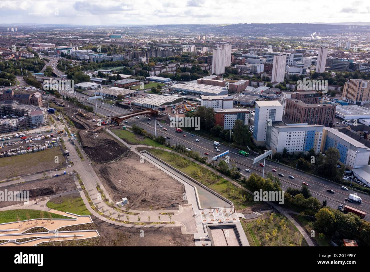 Glasgow, Schottland, Großbritannien. 29. September 2021 IM BILD: Neue Brücke bei Sighhill über die Autobahn M8. Luftdrohnenaufnahme des Stadtgebiets von Glasgow, die die neue Brücke über die Autobahn M8 zeigt, die nördlich des Stadtzentrums vom Osten nach Charing Cross führt. Im Gebiet von Sighthill werden im Norden der Stadt Investitionen in Höhe von 250 Millionen £in neue Erholungsgebiete und sozialen Wohnungsbau getätigt. In der Gegend gibt es auch Wildwasser-Rafting- und Kajaktrainingszentren sowie Wakeboarding-Trainingseinrichtungen. Quelle: Colin Fisher Stockfoto