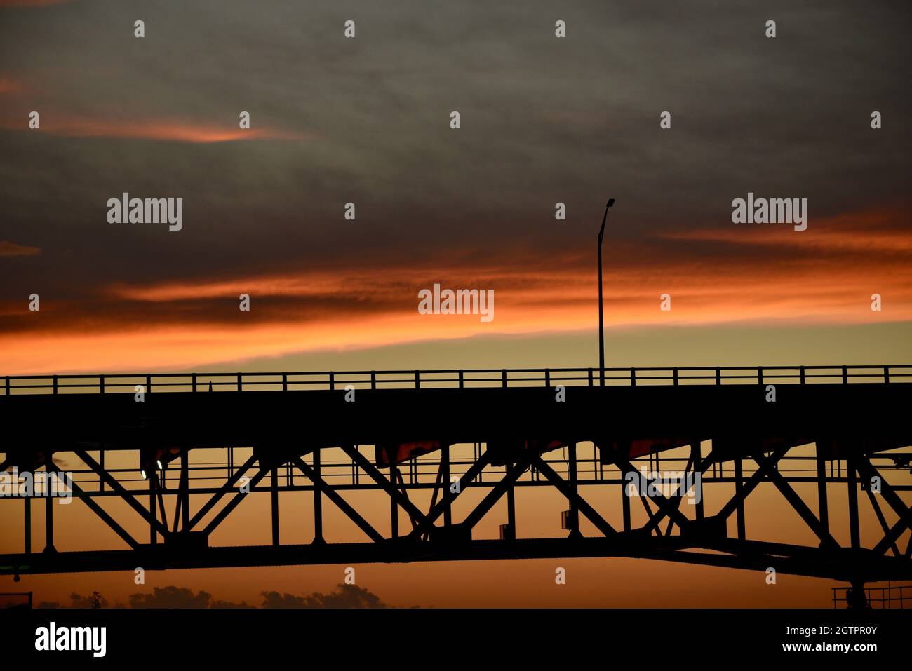 Leere Mautstraße auf der Mackinac Bridge, einer der längsten Brücken der Welt über die Straße von Mackinac, bei Sonnenuntergang, Mackinaw City, MI, USA Stockfoto