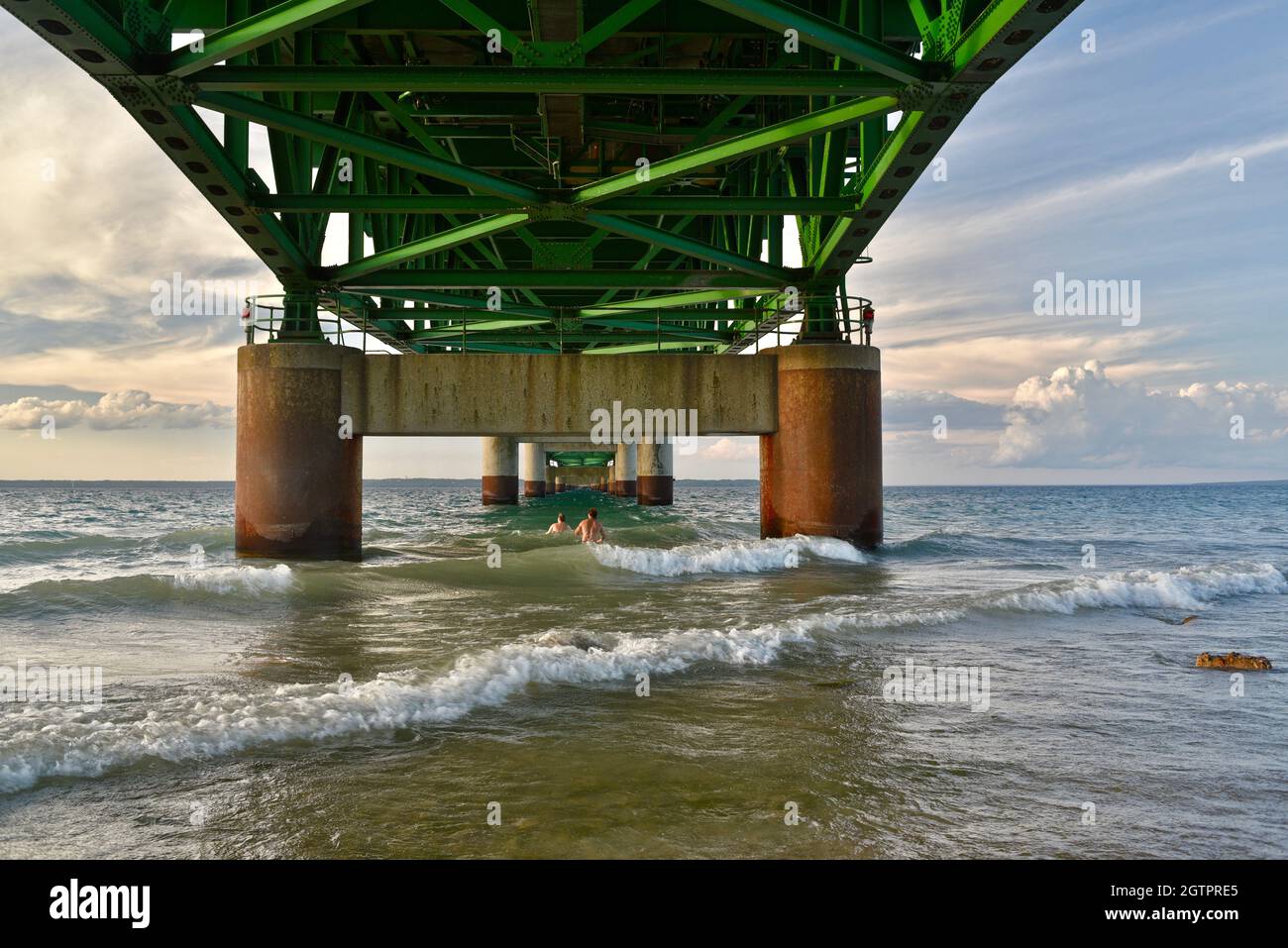 Pfeilerstützen unter der Mackinac Bridge, einer der längsten Brücken der Welt über die Straße von Mackinac, Wellen brechen, Mackinaw City, MI, USA Stockfoto