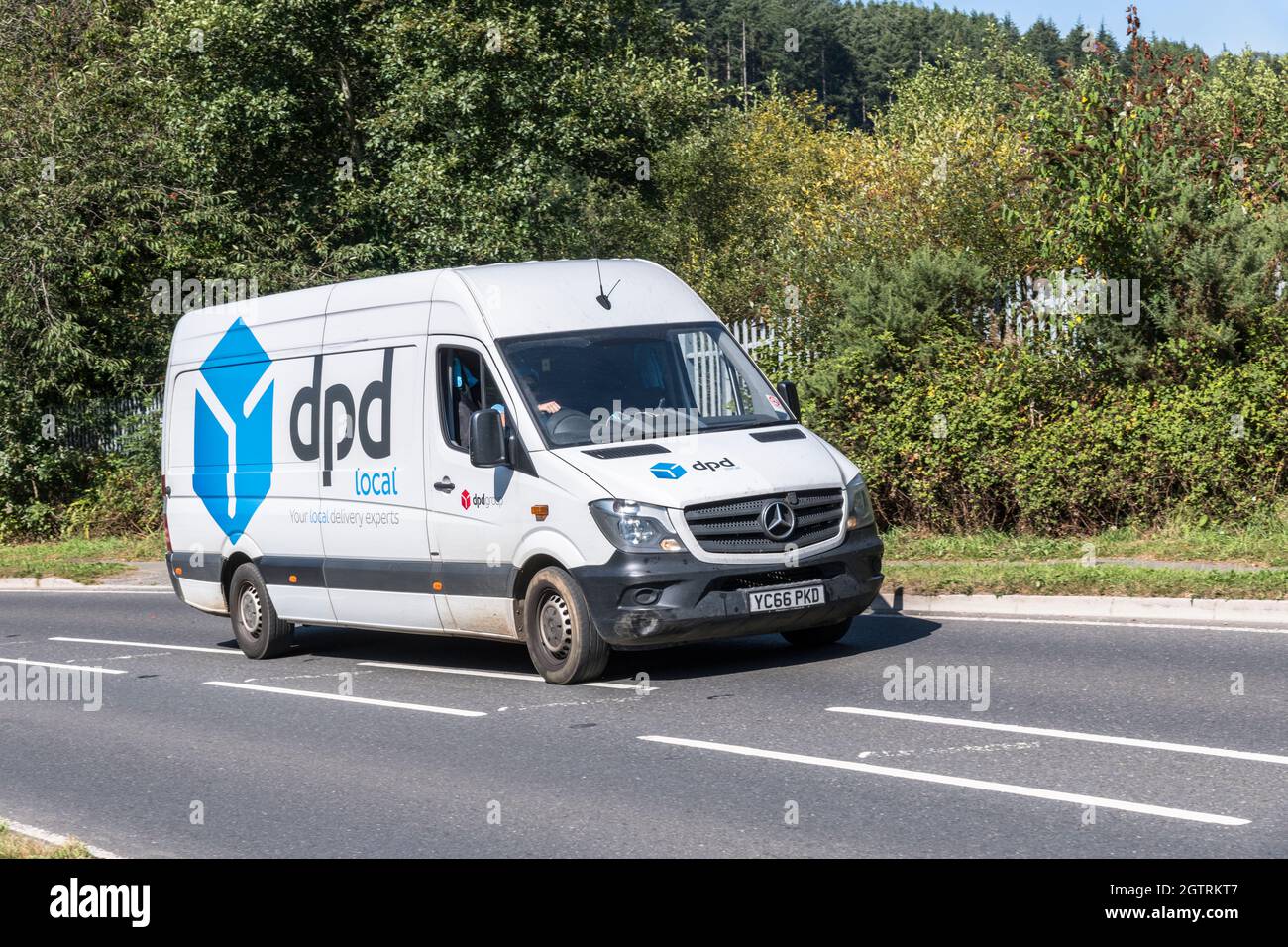 Weißer DPD lokaler Lieferwagen (Mercedes) fährt auf der Landstraße hinauf. Für UK Fahrer Mangel, Paketlieferungen während Covid, UK Transport Stockfoto