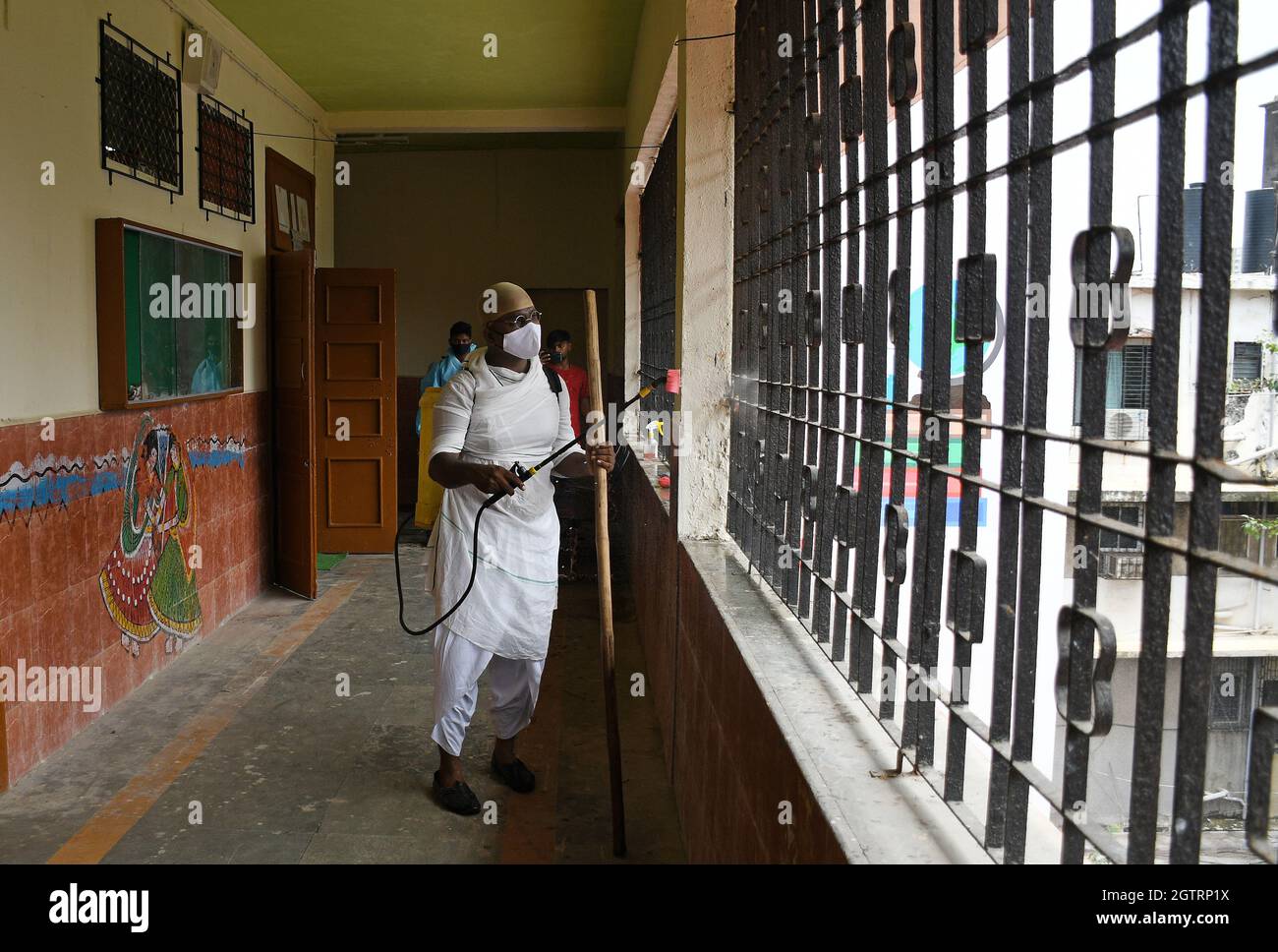 Ein Mann, der in einem Schutzanzug gekleidet ist, sprüht Desinfektionsmittel an der Sion Municipal High School als vorbeugende Maßnahme gegen die Verbreitung von covid-19. (Foto von Ashish Vaishnav / SOPA Images/Sipa USA) Stockfoto