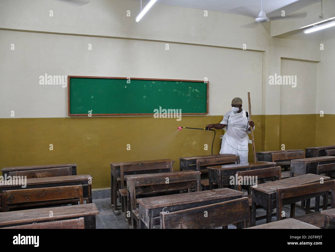 Ein Mann, der in einem Schutzanzug gekleidet ist, sprüht Desinfektionsmittel in einem Klassenzimmer der Sion Municipal High School als vorbeugende Maßnahme gegen die Ausbreitung von covid-19. (Foto von Ashish Vaishnav / SOPA Images/Sipa USA) Stockfoto
