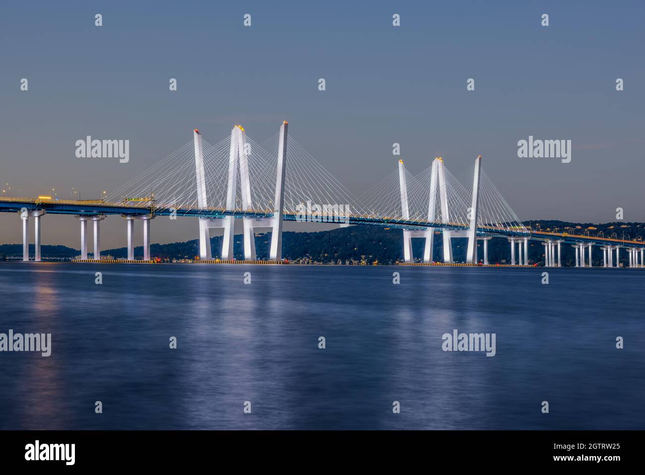 Die mit weißen Lichtern beleuchtete Governor Mario M. Cuomo Bridge überspannt den Hudson River während der morgendlichen Dämmerung. Stockfoto
