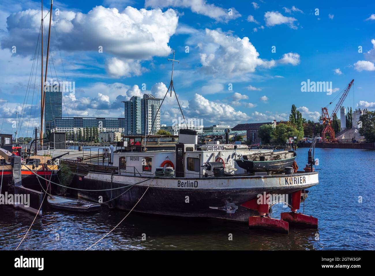 Barge vertäute an der Spree mit den Treptowers im Hintergrund, Berlin, Deutschland Stockfoto