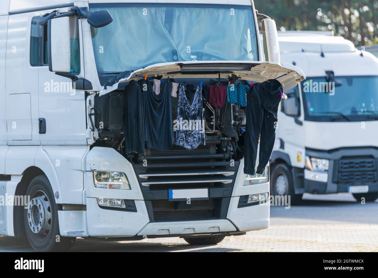 Ein LKW-Fahrer hängte seine gewaschene Wäsche an die geöffnete Motorklappe Stockfoto