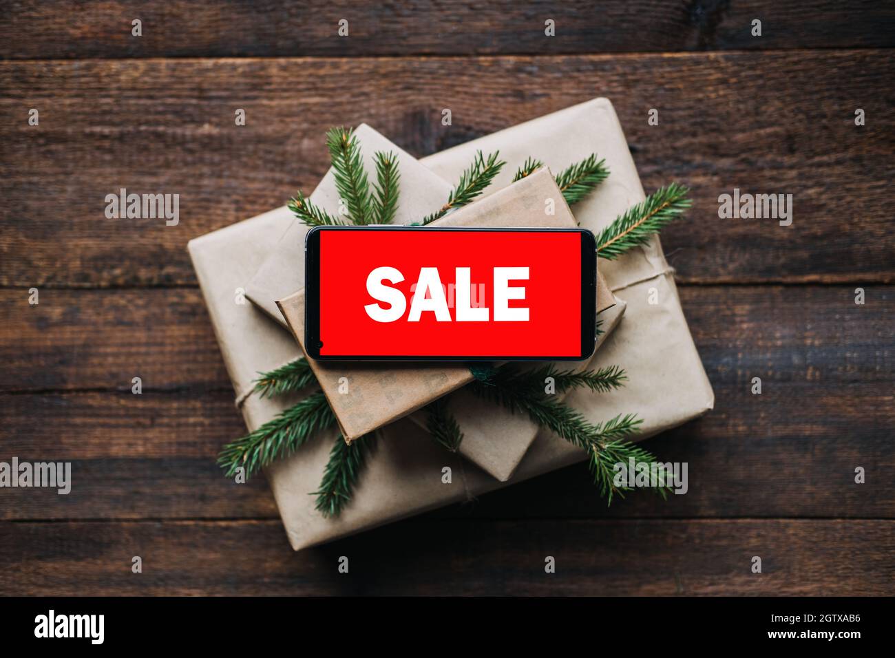 Weihnachtsverkauf, Weihnachten Online-Shopping, Winterurlaub Verkäufe, Black Friday. Handy mit rotem Bildschirm Verkaufstext auf Stapel von weihnachtsgeschenkschachteln mit Stockfoto