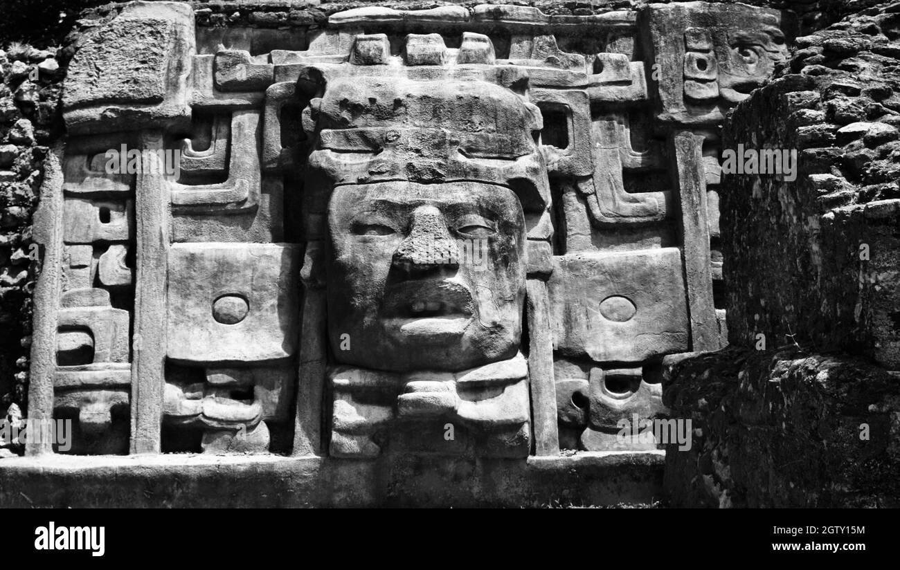 Monochrome Nahaufnahme der linken Maske an der Fassade des Maskentempels in Lamanai. Stockfoto