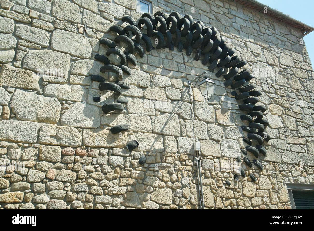 Künstler verwenden alte Reifen, um Wandkunst in Porto, Portugal, zu kreieren. Urbane Kunstwerke aus Reifen. Stockfoto