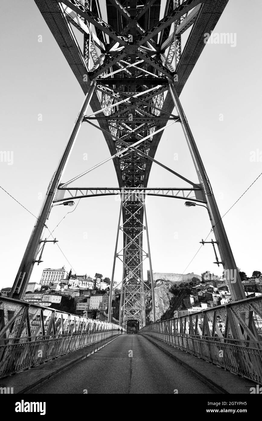 Blick unter/unter der Brücke Luís I, Porto, Portugal . Die Dom Luís i Brücke, von unten gesehen entlang der Straße/Pfad. Doppelstockbrücke in B&W. Stockfoto