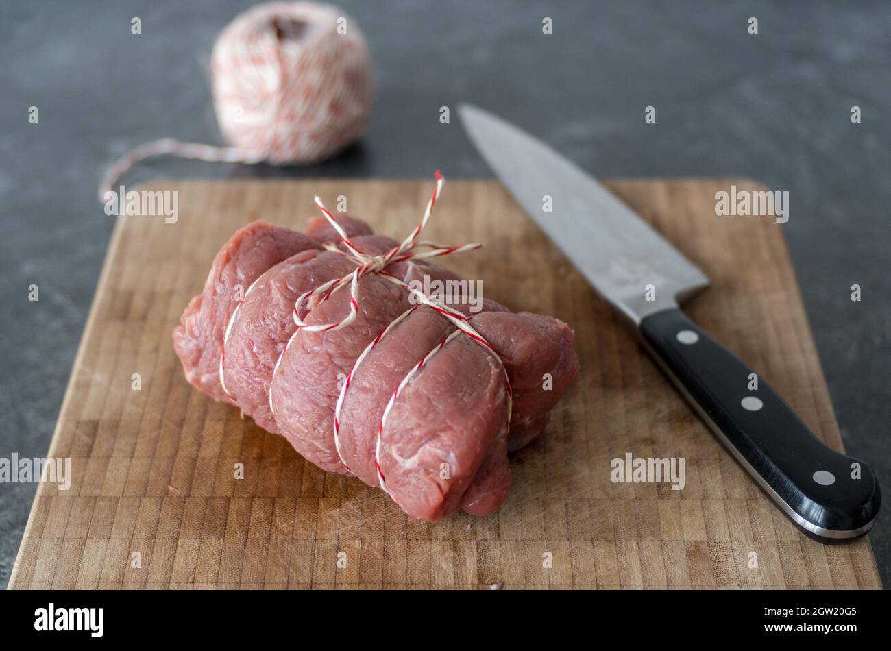Fleisch in einer Rolle für Eine Brate mit Küchenzinn gebunden  Stockfotografie - Alamy