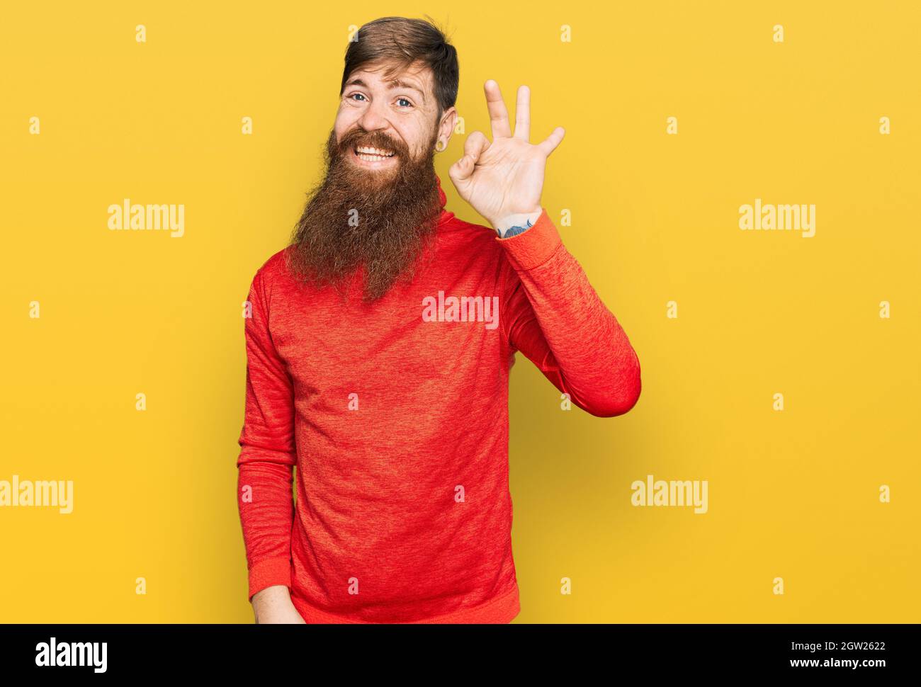 Rotschopf Mann mit langen Bart tragen lässige Kleidung lächelnd positiv tun ok Zeichen mit Hand und Fingern. Erfolgreicher Ausdruck. Stockfoto