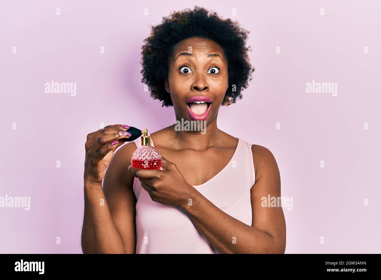 Junge afroamerikanische Frau mit Parfüm feiert verrückt und erstaunt über den Erfolg mit offenen Augen schreiend aufgeregt. Stockfoto