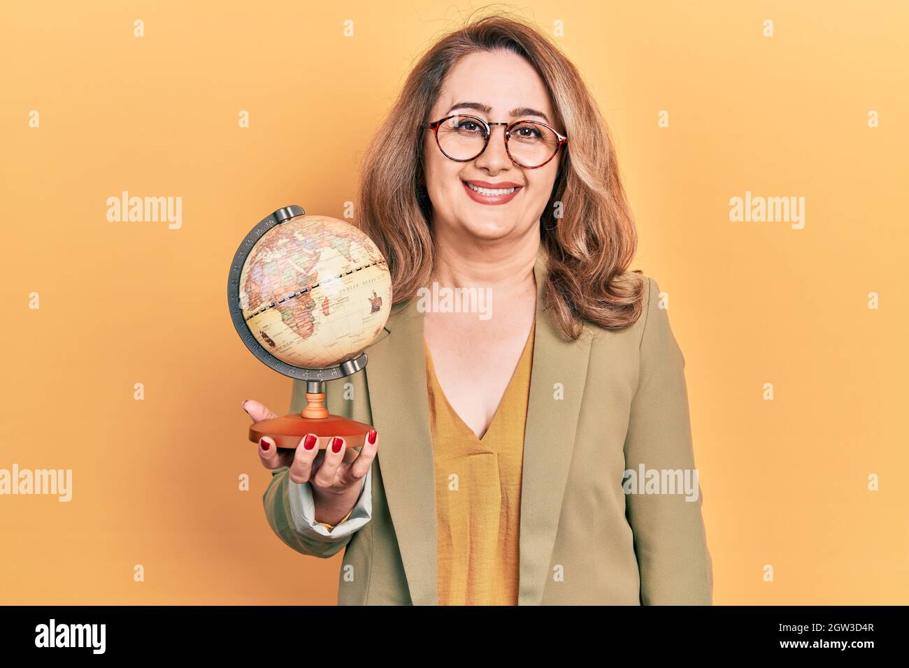 Kaukasische Frau mittleren Alters mit Vintage-Weltball, die positiv und glücklich stehend und lächelnd mit einem selbstbewussten Lächeln und Zähnen aussieht Stockfoto
