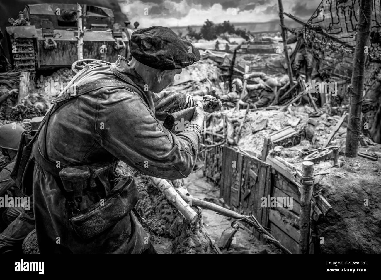 Alter sowjetischer Soldat, der mit einem Gewehr auf seinen Feind zielte. Historisches Diorama des Zweiten Weltkriegs mit dem Titel „Memory Speaks. A Way Through the war“. Schwarz und Weiß. Stockfoto