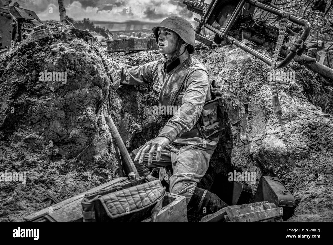 Junger sowjetischer Soldat in einem Graben, der nach Vorräten greift. Historisches Diorama des Zweiten Weltkriegs mit dem Titel „Memory Speaks. A Way Through the war“. Schwarz und Weiß. Stockfoto