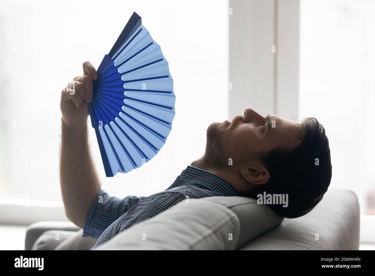 Profilansicht müde Mann winkt Papierventilator, leiden unter Hitze Stockfoto