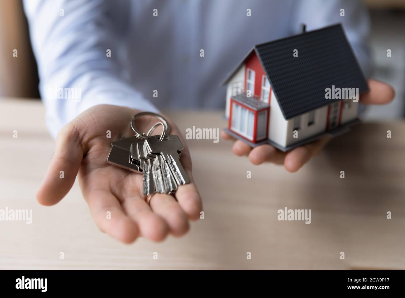 Crop Nahaufnahme Mann makler mit Schlüsseln und Hausmodell Stockfoto