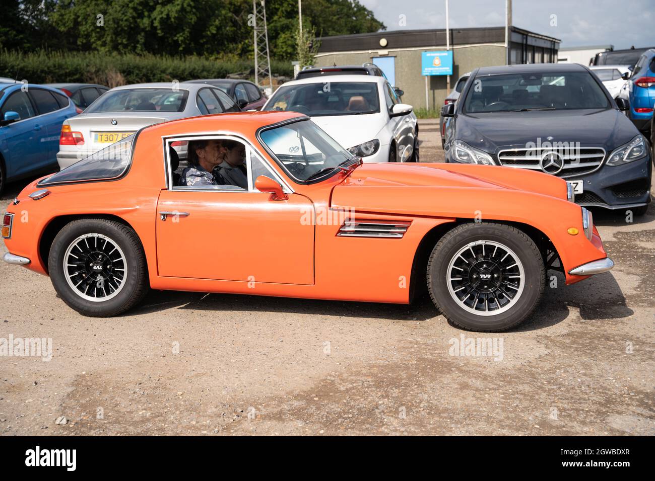 Orangefarbener TVR-Sportwagen auf der Automobilausstellung mit modernen Fahrzeugen im Hintergrund Stockfoto